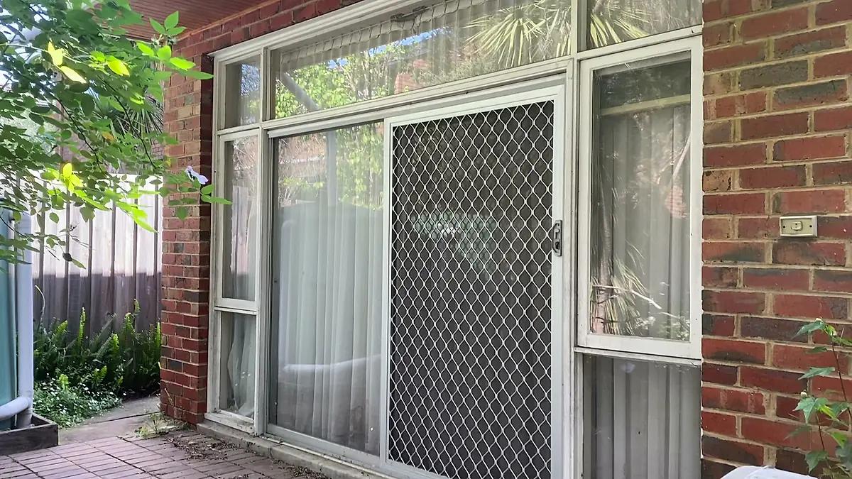 Cleaned exterior windows on a red brick home, glass reflecting the garden without haze