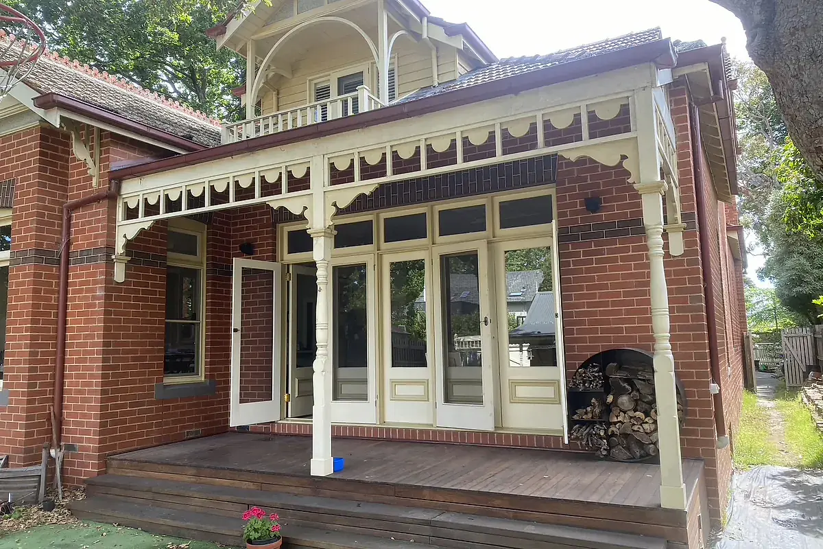 Federation red brick home with timber fretwork and French doors, the housing stock typical of Melbourne's inner east